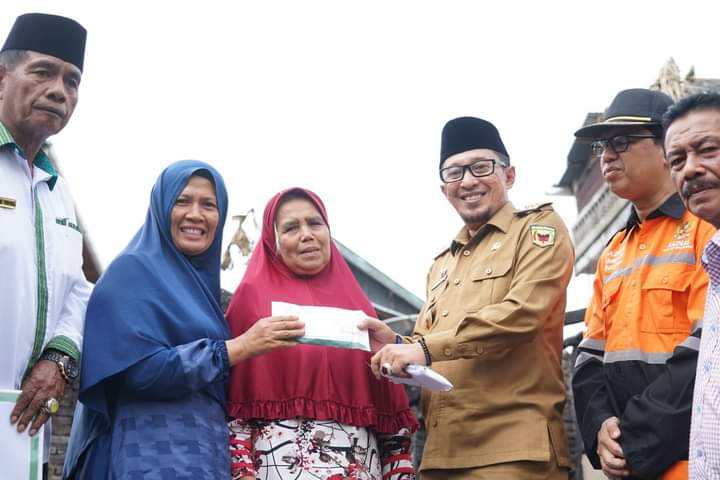 Bupati Tanah Datar Eka Putra saat menyerahkan bantuan kebakaran di Nagari Simabur, Kecamatan Pariangan, Senin (1/8)