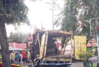 Satu unit mobil box berwarna kuning usai bagian atas mobil menabrak pohon.
