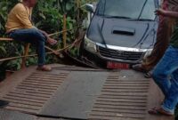 Mobil berplat merah yang tersangkut di jembatan yang menghubungkan dua kecamatan di Pesisir Selatan