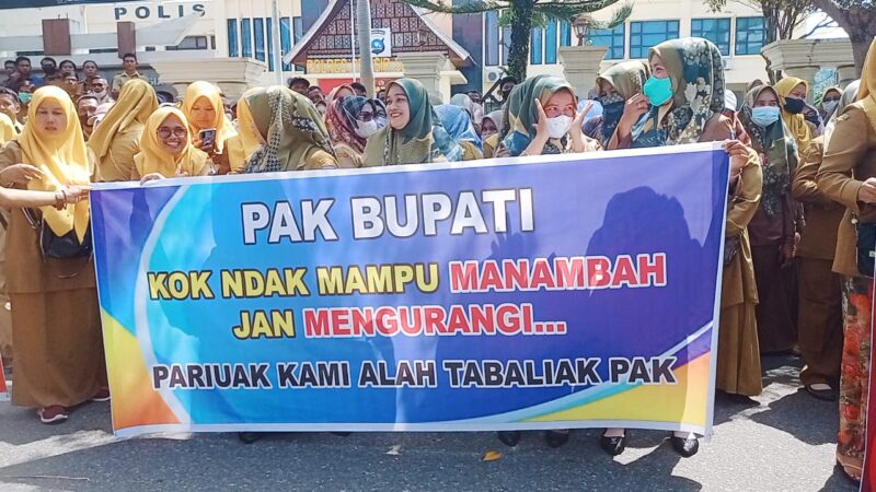 Perangkat nagari yang berdemonstrasi di depan Halaman Kantor Bupati Pesisir Selatan sambil membawa spanduk yang bertuliskan 