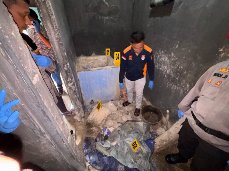 Petugas kepolisian melakukan olah TKP di lokasi penemuan kerangka manusia yang tertimbun dalam bak mandi berlapis semen di Bukit Ransam, Painan Selatan.
