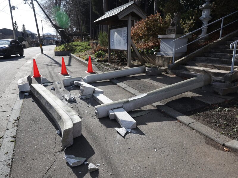 Sebuah kendaraan terhenti di tepi jalan yang runtuh di kota Tohoku di Prefektur Aomori, pada tanggal 9 Desember 2025, menyusul gempa berkekuatan 7,5 skala Richter di lepas pantai utara Jepang (JIJI Press/AFP)