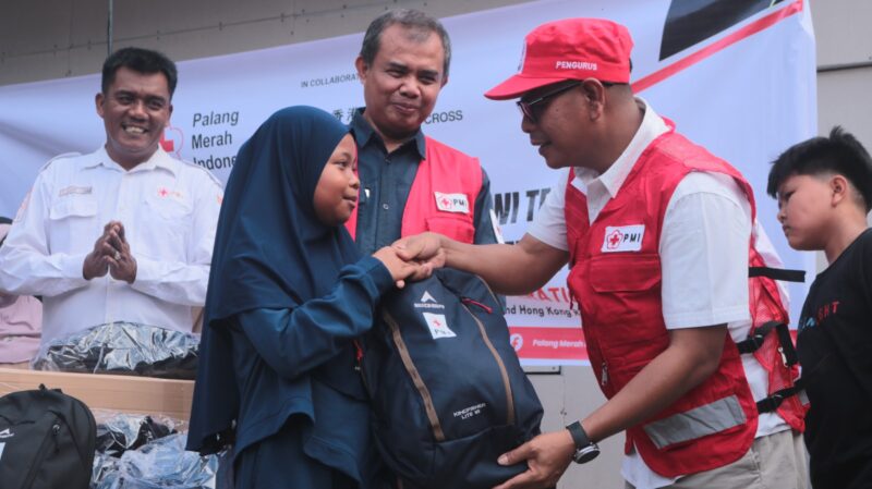 Wakil Bupati sekaligus Ketua PMI Pesisir Selatan saat menyerahkan paket school kit untuk anak-anak di huntara Bayang Utara, Senin (1/6/2026)